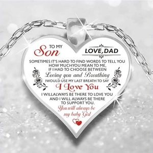 Macro detail of silver heart pendant with engraved message and rose motifs