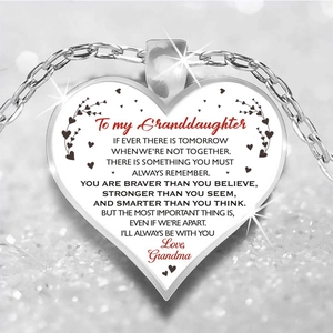 Macro shot of silver heart pendant with To My Granddaughter engraving and shiny background