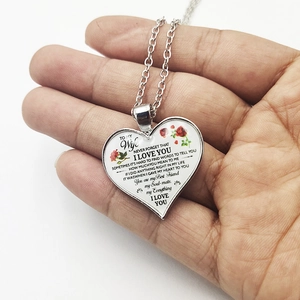 Detail of silver heart necklace with To My Wife engraving and red rose floral design