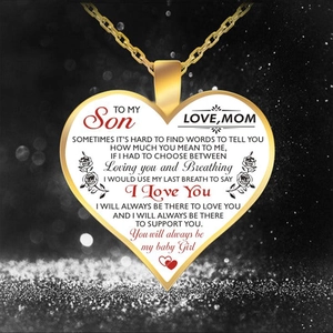 Macro shot of gold heart necklace with sentimental message for son on black bokeh background
