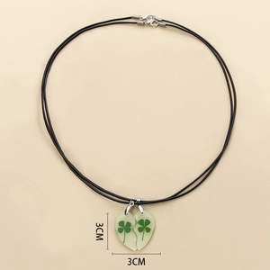 Detailed view of 3cm split-heart luminous pendants with real four-leaf clovers inside