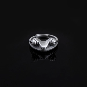 Close-up of vintage frog ring with detailed silver texture and carnelian stone accent