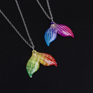 Exquisite mermaid tail necklaces in gradient colors on a textured black background