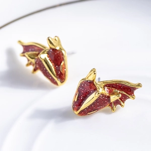 Macro detail of red enamel dragon head stud earrings with gold plating and silver glitter