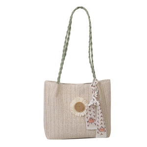 Sac fourre-tout en paille tissée beige avec anses vertes tressées et détail tournesol