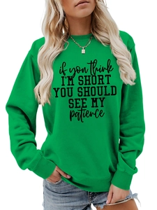 Detail of green crewneck sweatshirt featuring black humor slogan print and ribbed cuffs