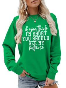 Detail of green crew neck sweatshirt with white slogan print and ribbed knit texture
