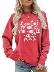 Close-up of funny white letter print on a red long sleeve casual crewneck sweatshirt