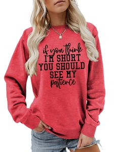 Detail of red crewneck sweatshirt with humorous slogan and ribbed cuffs close-up