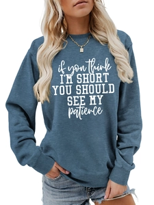 Detailed view of blue crewneck sweatshirt with white slogan print and ribbed collar