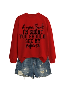 Close-up of funny slogan print on red crewneck sweatshirt with distressed denim shorts