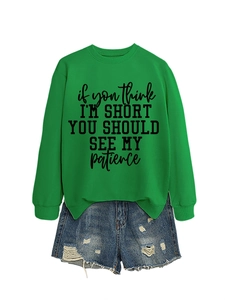 Detail of green crewneck sweatshirt with slogan and distressed denim shorts set