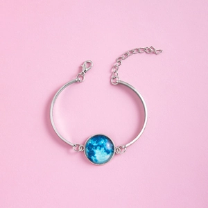 Bracelet argenté réglable avec cabochon en verre lune bleue sur fond rose