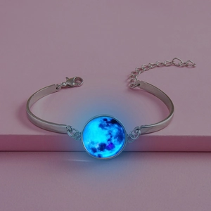 Détail du pendentif lune lumineuse sur un bracelet réglable en argent pour enfant