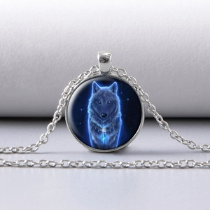 Dettaglio del ciondolo a lupo argentato con totem galassia blu luminoso su catena sottile