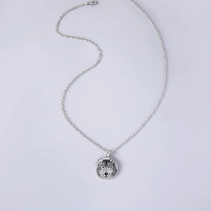 Dettaglio della collana totem lupo con ciondolo cabochon in vetro e catena argento