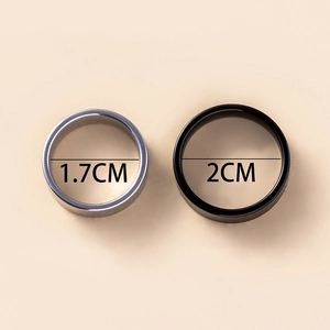 Détail de bagues en acier argenté et noir montrant des diamètres internes de 1,7 cm et 2 cm