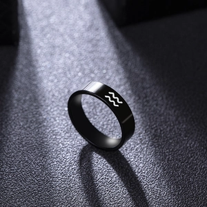 Black stainless steel Aquarius zodiac ring with laser engraved symbol on dark background