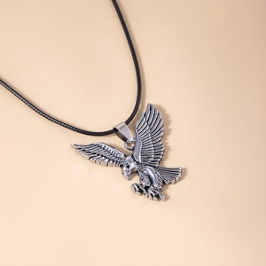 Détail du pendentif aigle argenté vintage avec plumes ciselées sur cordon noir