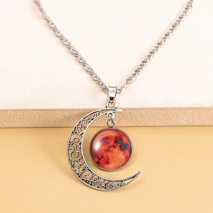 Detailed view of vintage silver crescent moon pendant with glowing red celestial orb