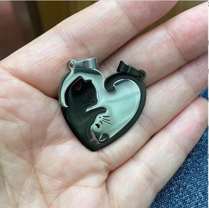 Nahaufnahme der Katzen-Puzzle-Halsketten in Schwarz und Silber für Paare