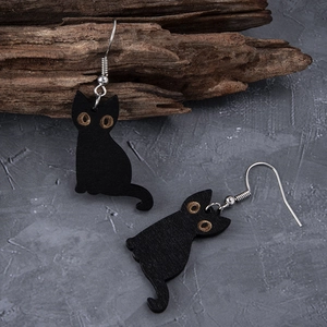 Gothic black wooden cat earrings with silver hooks on dark stone background