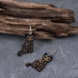 Detail view of gothic wooden cat skull earrings with gold laser etching on black finish