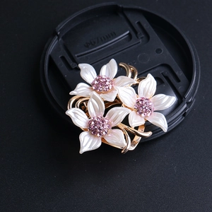 Broche élégante à trois fleurs avec pétales nacrés et cristaux roses sur base dorée