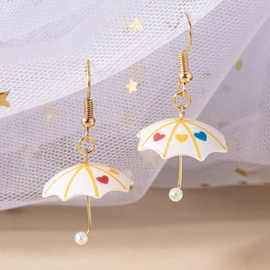 Macro shot of colorful umbrella earrings with heart patterns and gold-plated hooks