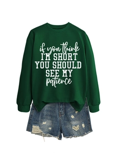 Detail of dark green sweatshirt with white text and distressed denim shorts