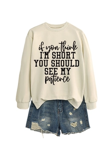 Detail of off-white sweatshirt with slogan print and distressed denim shorts set