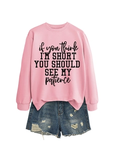Pink crewneck sweatshirt detail featuring black text slogan and blue denim shorts combo