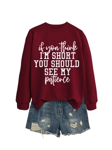 Detail of burgundy sweatshirt with white text slogan and distressed denim shorts