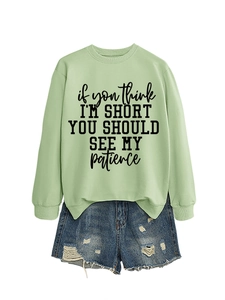 Detailed view of casual mint green sweatshirt with fun quote and distressed denim shorts