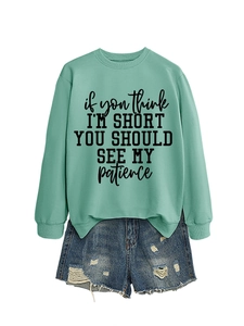 Detail of mint green sweatshirt with humor slogan and distressed denim shorts set