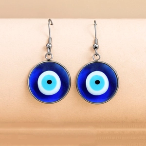 Ethnic blue evil eye drop earrings with silver fishhook earwire on soft orange background