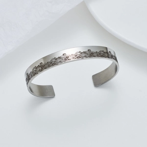 Vista macro del bracciale aperto in acciaio da 10mm con motivo a onde inciso