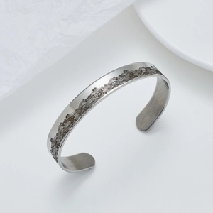 Dettaglio dei motivi a onde incisi su un bracciale rigido in acciaio da 10 mm
