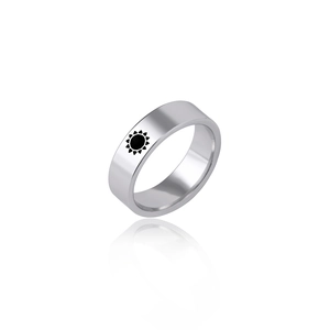 Macro detail of silver titanium ring featuring a black sun symbol with mirror reflection