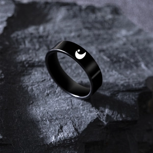 Matte black titanium ring featuring white celestial moon and star patterns on stone