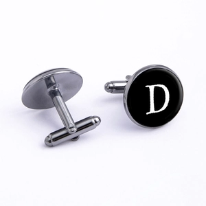 Detailed view of gunmetal cufflinks featuring a polished black disc with a white letter D
