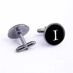 Macro shot of gunmetal cufflink featuring a black disc with a white serif letter I