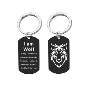 Détail des porte-clés dog tag en acier noir avec tête de loup et citations gravées