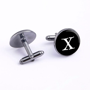 Macro view of gunmetal round cufflinks with black enamel inlay and white letter X design