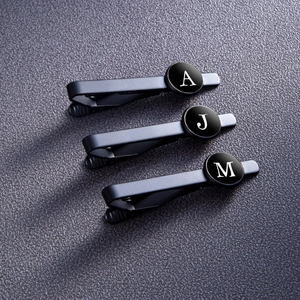 Set of three matte black stainless steel letter tie clips with white initials A, J, M