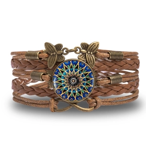 Detail of bohemian multilayer bracelet with mandala glass charm and infinity metal charms