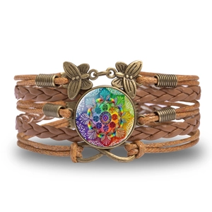 Detail of bohemian mandala glass gem on multilayer braided leather bracelet with butterfly charm