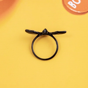 Gothic matte black bat wing ring for Halloween, dark aesthetic jewelry on orange background
