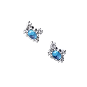 Macro shot of silver crab earrings featuring blue gemstone centers and sparkling crystals
