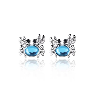 Detail of silver crab earrings featuring blue crystal centers and sparkling accents